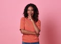 Portrait of a beautiful young african girl standing over pink background, showing silence gesture Royalty Free Stock Photo