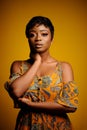 Portrait of a beautiful young African woman over yellow background. Studio picture