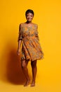 Portrait of a beautiful young African woman over yellow background. Studio picture