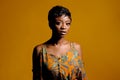 Portrait of a beautiful young African woman over yellow background. Studio picture