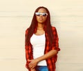 Portrait of beautiful young african woman posing wearing casual, sunglasses in the city