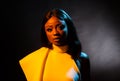 Portrait of a beautiful young African woman in white dress over black background