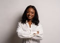 Portrait of a beautiful young African woman in white dress over grey background Royalty Free Stock Photo