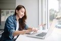 Young Asia woman smiling and looking at laptop screen Royalty Free Stock Photo