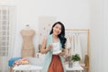 Portrait of beautiful young Asian fashion designer businesswoman at her studio while drinking coffee Royalty Free Stock Photo
