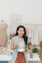 Portrait of beautiful young Asian fashion designer businesswoman at her studio while drinking coffee Royalty Free Stock Photo