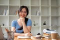 A beautiful Asian female college student in glasses sits at her study table at home Royalty Free Stock Photo