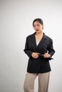 A portrait of a beautiful young Asian female model in an elegant suit posing in a photoshoot studio Royalty Free Stock Photo