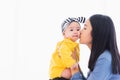 Mother kissing her infant newborn baby in a white bed Royalty Free Stock Photo