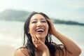 Portrait of beautiful young asian woman with amazing toothy smile. Girl with wet hair enjoying sunny day on the beach. Happy Royalty Free Stock Photo