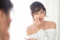 Portrait beautiful young asian woman applying powder puff at cheek makeup of cosmetic looking mirror Royalty Free Stock Photo