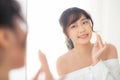 Portrait beautiful young asian woman applying powder puff at cheek makeup of cosmetic looking mirror Royalty Free Stock Photo