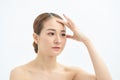 Portrait of beautiful young Asian woman with bare shoulders touching her temples feeling stress, on white background Royalty Free Stock Photo