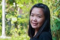 Portrait of beautiful young Asian woman dresses casually smiling and looking at a camera with a natural background. Happy and Royalty Free Stock Photo