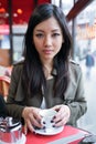 Beautiful young asian woman drinking coffee in the terrace of a coffee shop. Royalty Free Stock Photo