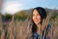 Portrait of beautiful young Asian woman enjoying nature on grass meadow at sunrise Royalty Free Stock Photo