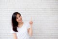 Portrait of beautiful young asian woman happiness standing finger pointing something on gray cement texture
