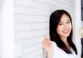 Portrait of beautiful young asian woman happiness standing on gray cement texture grunge wall brick background. Royalty Free Stock Photo