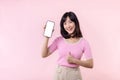 Portrait beautiful young asian woman happy smile showing smartphone screen with pointing finger hand gesture to mobile phone Royalty Free Stock Photo