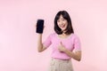 Portrait beautiful young asian woman happy smile showing smartphone screen with pointing finger hand gesture to mobile phone Royalty Free Stock Photo