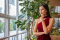 portrait of Beautiful young asian woman in red dress standing and looking out the window . elegant lady model positive thinking Royalty Free Stock Photo