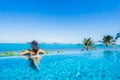 Portrait beautiful young asian woman relax in luxury outdoor swimming pool in hotel resort nearly beach sea ocean Royalty Free Stock Photo