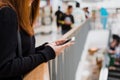 Portrait of beautiful young asian woman in shopping mall, smiling using smart phone to network indoors. Royalty Free Stock Photo