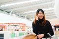 Portrait of beautiful young asian woman in shopping mall, smiling using smart phone to network indoors. Royalty Free Stock Photo