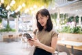 Portrait beautiful young asian woman with smart mobile phone in cafeteria at shopping mall Royalty Free Stock Photo