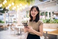 Portrait beautiful young asian woman with smart mobile phone in cafeteria at shopping mall Royalty Free Stock Photo