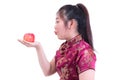 Portrait of Beautiful Young asian woman wear chinese dress traditional cheongsam or qipao. Eating red apple, isolated on white ba Royalty Free Stock Photo