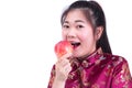 Portrait of Beautiful Young asian woman wear chinese dress traditional cheongsam or qipao. Eating red apple, Royalty Free Stock Photo