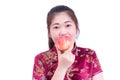Portrait of Beautiful Young asian woman wear chinese dress traditional cheongsam or qipao. Eating red apple, Royalty Free Stock Photo