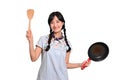 Portrait of beautiful young asian woman wear denim dress with black pan and spatula on white isolated background Royalty Free Stock Photo