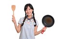 Portrait of beautiful young asian woman wear denim dress with black pan and spatula on white isolated background Royalty Free Stock Photo