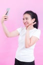 Portrait of beautiful young asian woman wear a white t-shirt. Using a smart phone taking selfie and smiling Royalty Free Stock Photo