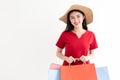 Portrait of beautiful young asian woman wearing red long dress  holding shopping bags isolated over white background. Royalty Free Stock Photo