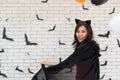 Portrait of beautiful young asian woman wearing witch costume posing with balloons on background decorated for party concept - Royalty Free Stock Photo