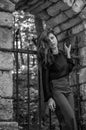 Portrait of a beautiful young and attractive teen girl with long hair near the steel gates of the destroyed stone castle in Royalty Free Stock Photo