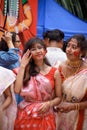 Portrait of beautiful young attractive woman wearing a traditional Bengali outfit and participating in Sindur Khela at a puja