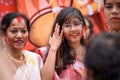 Portrait of beautiful young attractive woman wearing a traditional Bengali outfit and participating in Sindur Khela at a puja