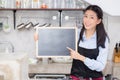 Portrait of beautiful young barista, asian woman is a employee standing holding chalkboard