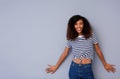 Beautiful young black woman in striped shirt smiling against gray wall Royalty Free Stock Photo