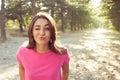 Portrait of beautiful young blinking woman against the sun background Royalty Free Stock Photo