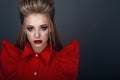 Portrait of beautiful young blond model with perfect provocative make up and stylish creative hairstyle wearing bright red blouse Royalty Free Stock Photo