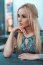 Portrait of a beautiful young blond woman in a blue dress with Royalty Free Stock Photo