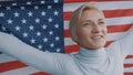Portrait of beautiful young blond woman holding USA flag Royalty Free Stock Photo
