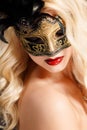 Portrait of a beautiful young blond woman with theatrical mask on his face on a dark background Royalty Free Stock Photo