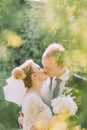 Portrait of beautiful young blonde bride and happy groom kissing on their wedding day outdoors Royalty Free Stock Photo
