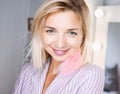 Portrait beautiful young blonde girl posing in the studio with professional make-up and earrings pink feathers in the ears Royalty Free Stock Photo